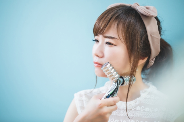 小顔対策　美顔ローラーでマッサージする女性